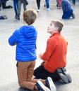 two young boys pray in Lourdes